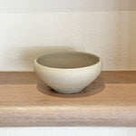 Handcrafted stoneware pedestal bowl on wooden shelf
