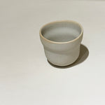 Handcrafted stoneware cloud cup on white surface