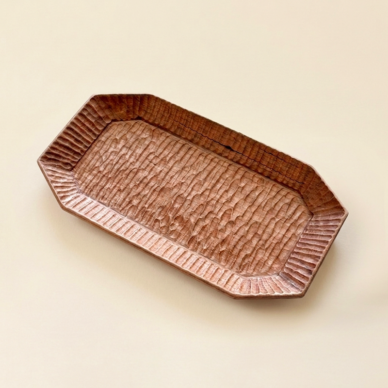 Hand-carved octagonal wooden tray with a ridged border and textured center