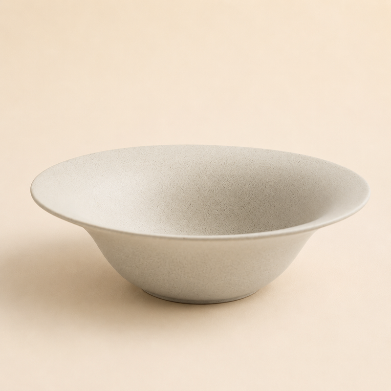 Wide shallow speckled cream stoneware bowl with a flared rim
