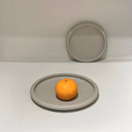 Drum-edge plate with orange on white surface