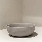 Handcrafted stoneware ribbed breakfast bowl on white surface