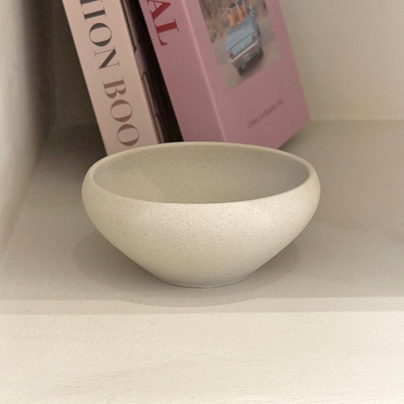 Bowl on shelf with books in background