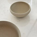 Two stoneware bowls on white marble surface
