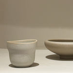 Cloud cup beside round bowl on shelf