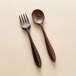 Dark walnut wood fork and spoon set on a neutral background