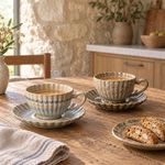 Blue Grey and Earth Brown cup and saucer sets on an oak breakfast table; each set sold separately