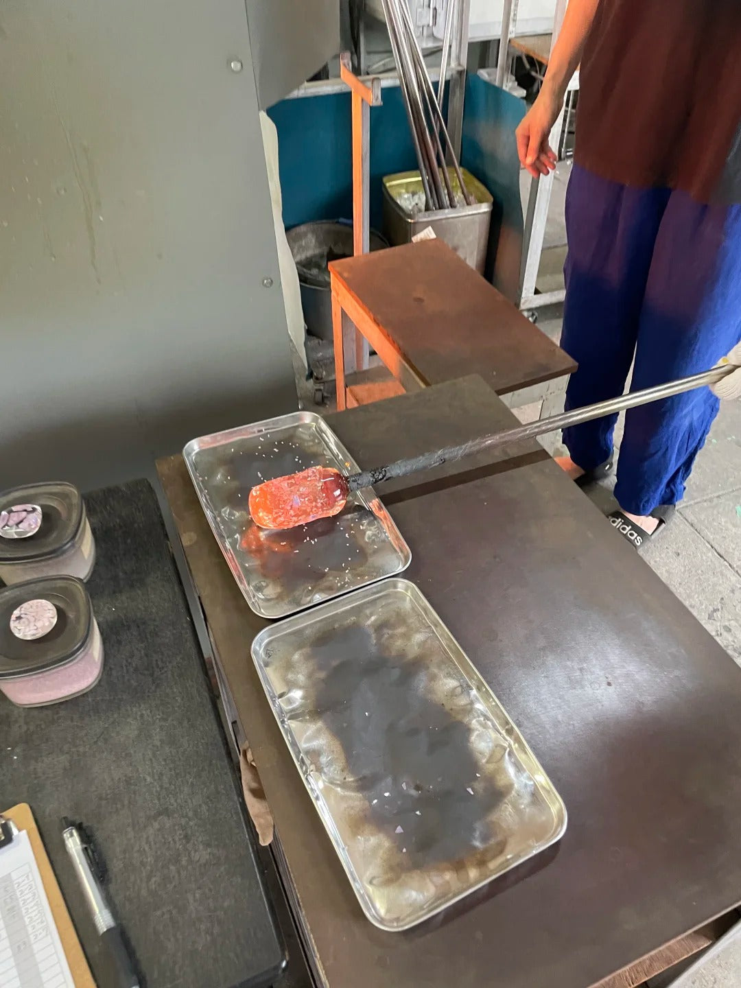 Hot glass on a rod above a metal work surface